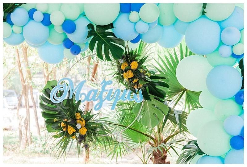 tropical garland with laser cut wooden name and blue balloon arch