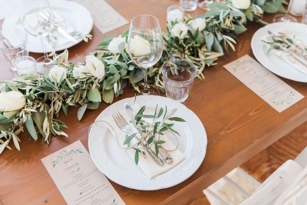 Wooden table with olive wedding decor and white flowers
